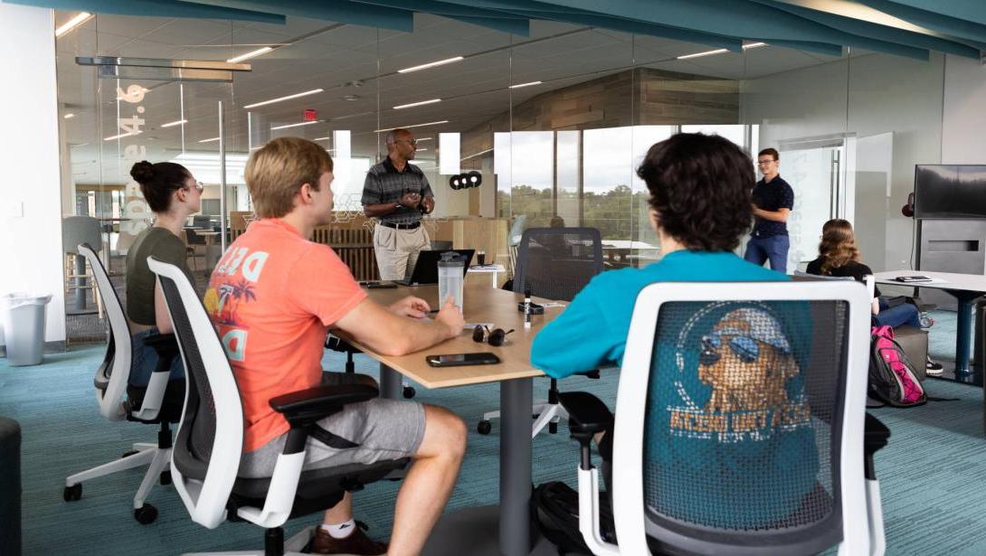 Business students sit around a table in the Learning Commons