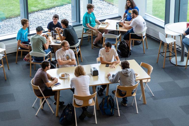 Groups of students gather for meals and discussions in the open and inviting seating area of the Learning Commons.